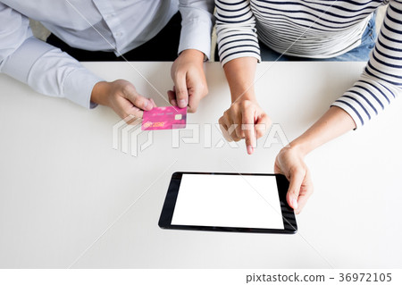 Happy young couple doing shopping online at home with tablet. Happy young couple doing shopping online at home with tablet. 36972105
