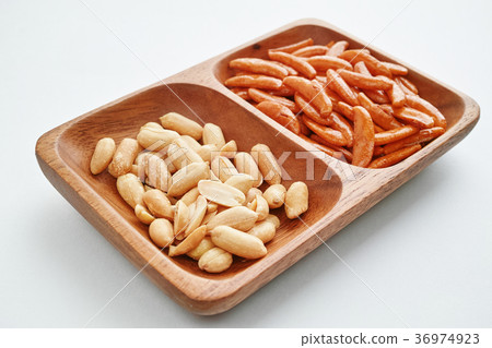 Peanut and persimmon seeds on a wooden plate Peanut and persimmon seeds on a wooden plate 36974923