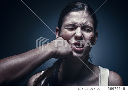 Male fist against kidnapped young woman in the 36976346