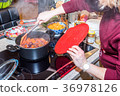 Female hand steering frying fresh carrots onions 36978126