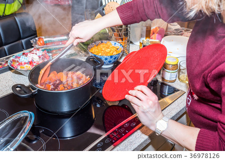 Female hand steering frying fresh carrots onions 36978126