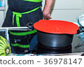 Black casserole pan with red plastic lid heating 36978147