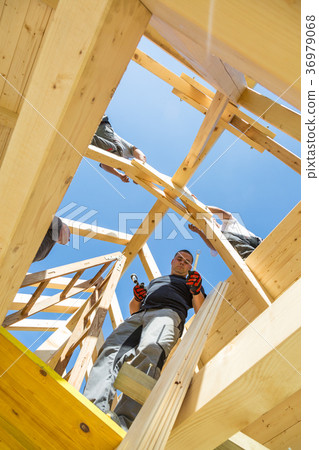 Builders at work with wooden roof construction. Builders at work with wooden roof construction. 36979068