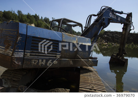 Broken excavator and basalt columns rocks. Heavy 36979070