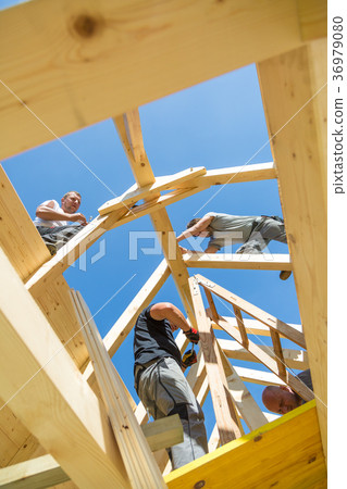 Builders at work with wooden roof construction. Builders at work with wooden roof construction. 36979080