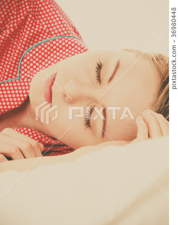 Woman sleeping in bed on the side 36980448