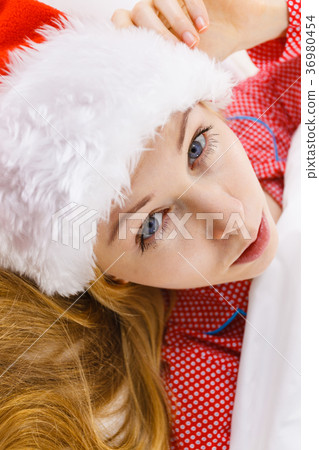 Happy woman wearing pajamas and Santa Claus hat Happy woman wearing pajamas and Santa Claus hat 36980454