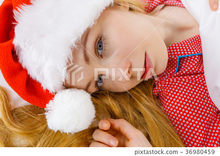 Happy woman wearing pajamas and Santa Claus hat Happy woman wearing pajamas and Santa Claus hat 36980459