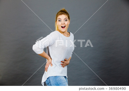 Happy woman touching her stomach and back Happy woman touching her stomach and back 36980490