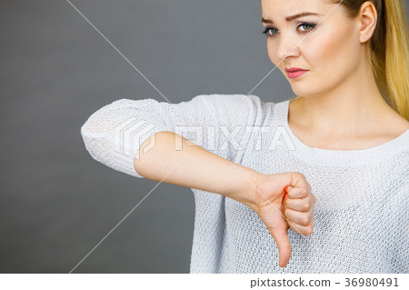 Sad woman showing thumb down gesture 36980491
