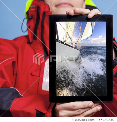 Man sailor showing yacht boat on tablet. Sailing Man sailor showing yacht boat on tablet. Sailing 36980830