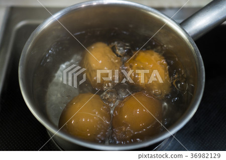 four eggs are cooked in a saucepan on the stove four eggs are cooked in a saucepan on the stove 36982129