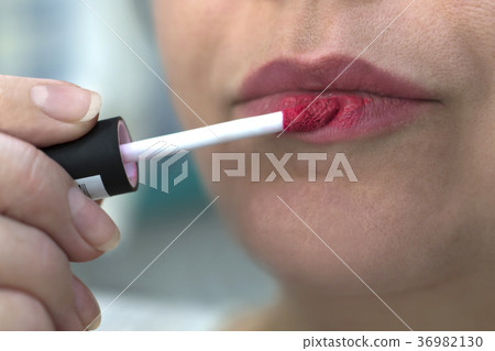 girl paints lips with bright red lipstick girl paints lips with bright red lipstick 36982130