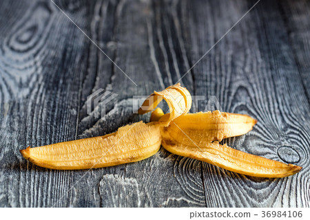 Banana skin lying on a wooden surface 36984106