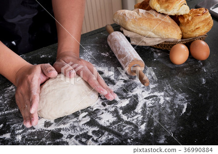 Woman's hands knead dough with flour, eggs and ingredients. at k 36990884