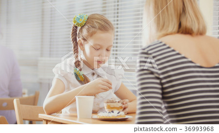 Mother and daughter eating breakfast at the table Mother and daughter eating breakfast at the table 36993968