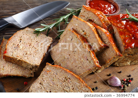 sliced meatloaf on wooden cutting board 36994774