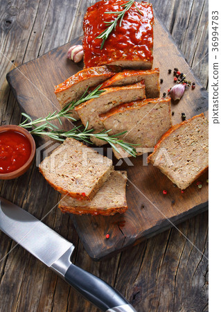 sliced meatloaf on wooden cutting board 36994783