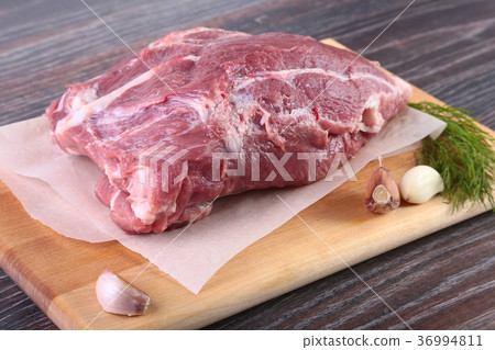 Raw pork steaks with herbs, spices, tomatoes. 36994811