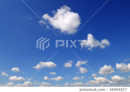 Light cumulus clouds against the blue sky. 36994857