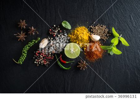 Flat-lay of spices and herbs on black background.  36996131