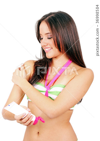 Woman applying suntan lotion in a white background 36998584