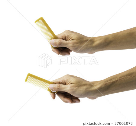 Hand holding comb isolated on white background 37001073