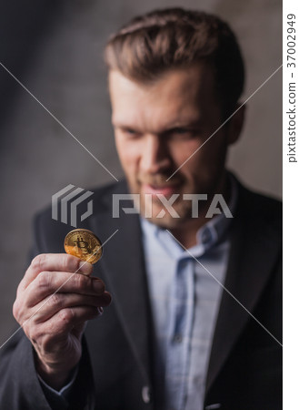 Greedy man looking at bitcoin 37002949