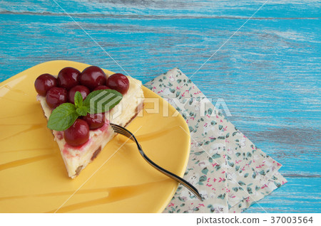 Yellow plate with a piece of cheesecake 37003564
