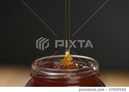 pour honey into glass jar closeup pour honey into glass jar closeup 37009588