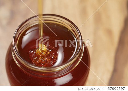 pour honey into glass jar closeup pour honey into glass jar closeup 37009597