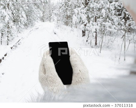 Girl is holding a mobile phone 37011318