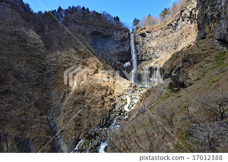 A magnificent panorama of Kegon Falls, one of Japan's most famous waterfalls, where snowmelt flows powerfully against a backdrop of blue sky and rugged cliffs. A magnificent panorama of Kegon Falls, one of Japan's most famous waterfalls, where snowmelt flows powerfully against a backdrop of blue sky and rugged cliffs. 37012388