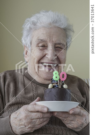 Senior woman with her birthday cake for age eighty Senior woman with her birthday cake for age eighty 37013641
