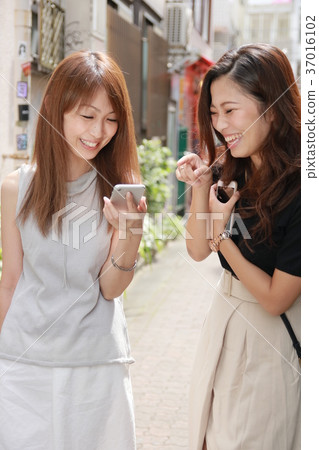 Two young women searching for smartphones 37016102
