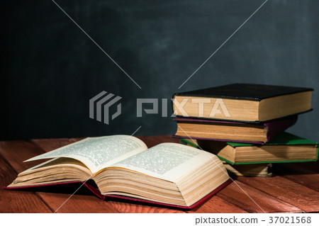 Old books on a wooden red table. 37021568