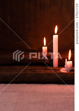 Candle on a old oak wooden table. Candle on a old oak wooden table. 37021729