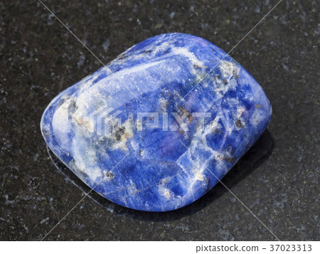 tumbled Sodalite gemstone on dark background 37023313