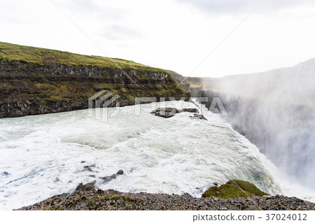 Gullfoss waterfall and water spray over canyon 37024012
