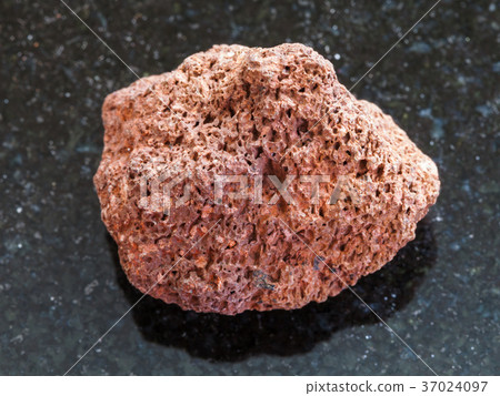 tumbled red pumice stone on dark background 37024097