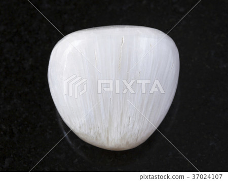 tumbled Scolecite gemstone on dark background tumbled Scolecite gemstone on dark background 37024107