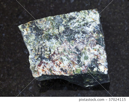 raw dunite stone on dark background 37024115