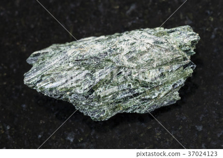 rough Actinolite stone on dark background rough Actinolite stone on dark background 37024123
