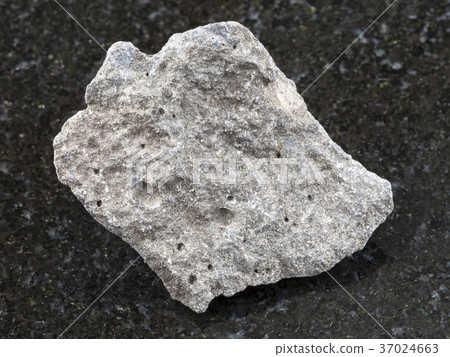 pebble of gray basalt stone on dark background 37024663