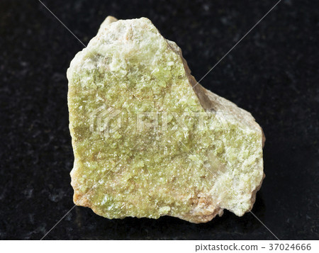 green Vesuvianite crystals on raw stone on dark 37024666