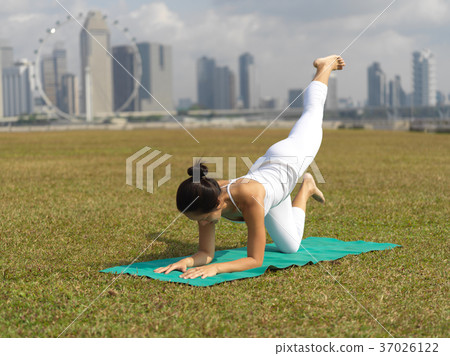 Asian chinese woman practising yoga outdoors in Singapore 37026122
