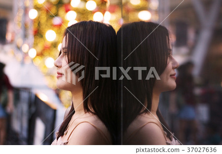 Smilely women stand near wall background which have women picture on reflect, Valentine concept. 37027636