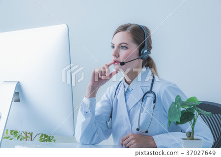 Female doctor speaking on a video phone 37027649