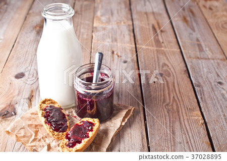 black currant jam in glass jar, milk and crackers 37028895