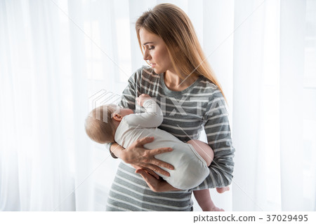 Caring mother lulling her baby to sleep Caring mother lulling her baby to sleep 37029495